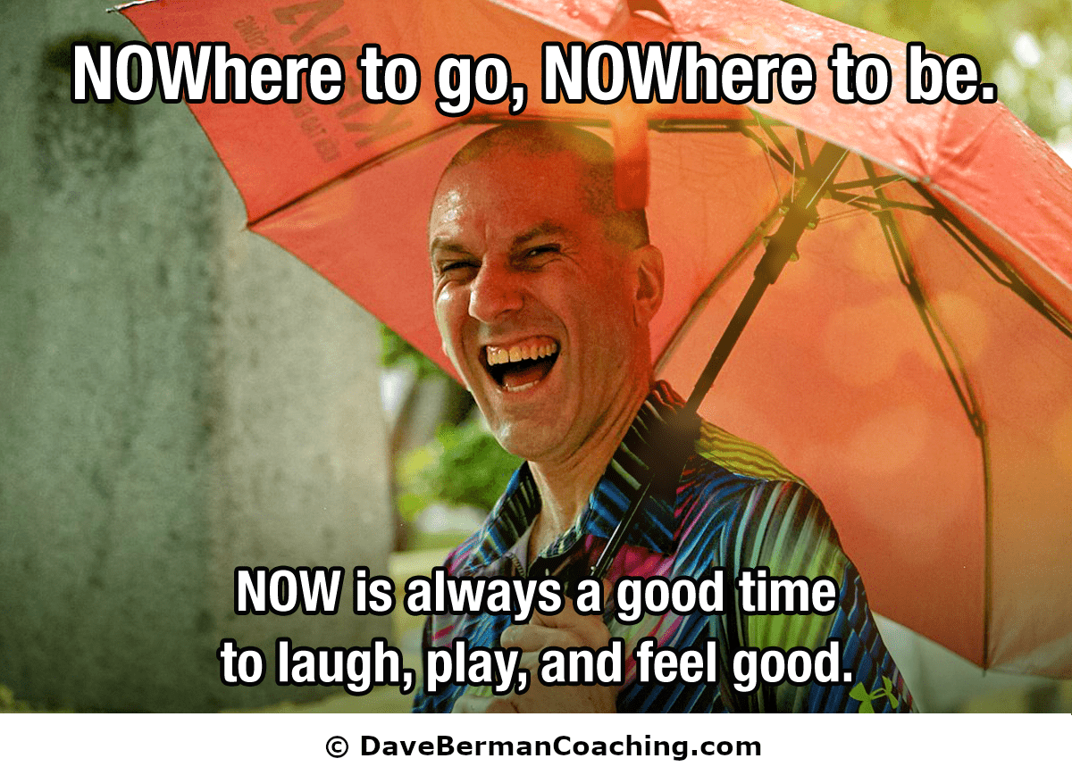 Dave Berman laughs under an umbrella in the rain. Words across the top: "NOWhere to go, NOWhere to be." and across the bottom: "NOW is always a good time to laugh, play, and feel good."  © DaveBermanCoaching.com